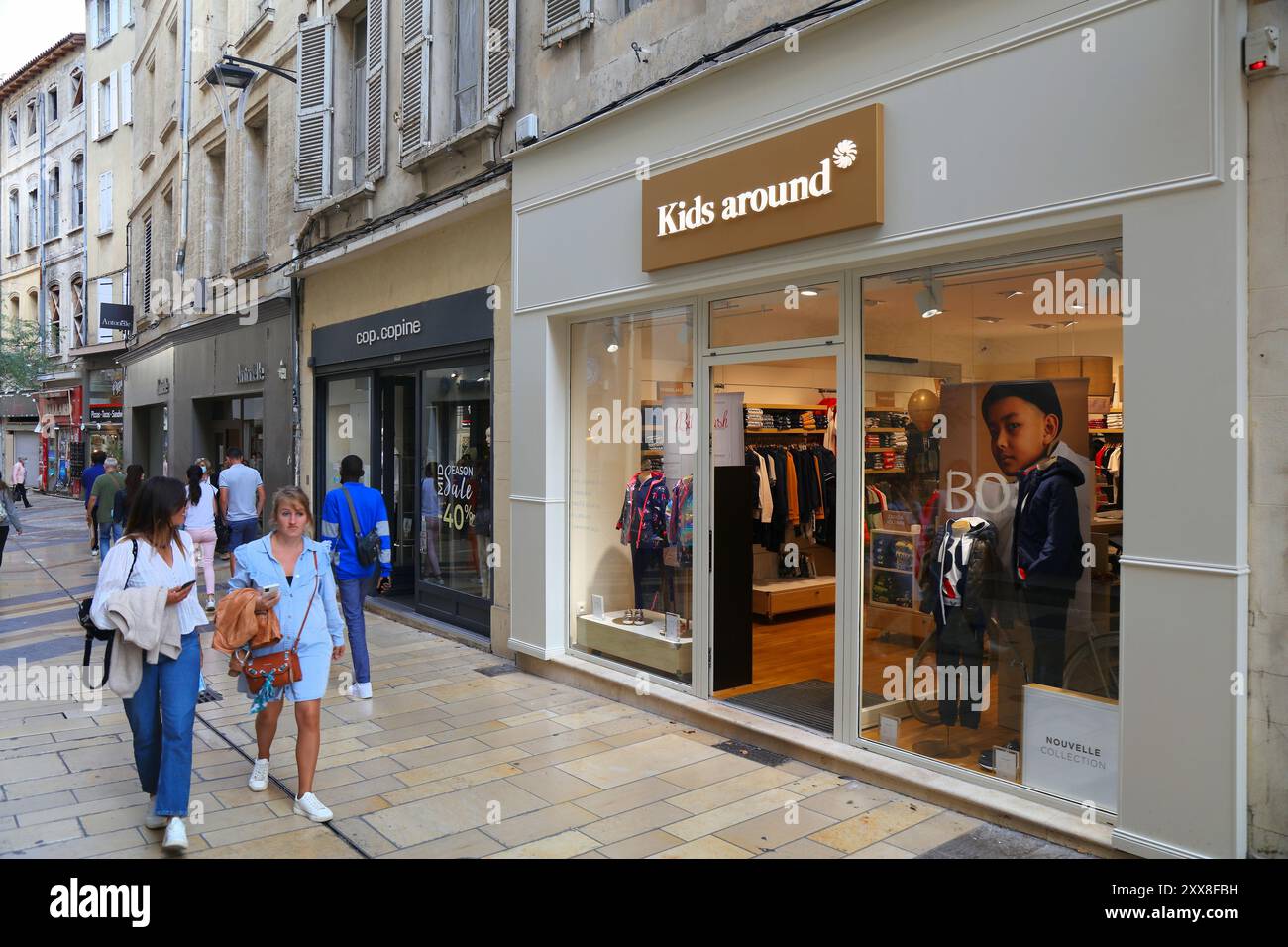 AVIGNON, FRANKREICH - 30. SEPTEMBER 2021: Leute spazieren vorbei an Kindern in einem Modegeschäft in Avignon, Frankreich. Kids Around ist eine Mehrmarken-Ladenkette, die sich auf die konzentriert Stockfoto