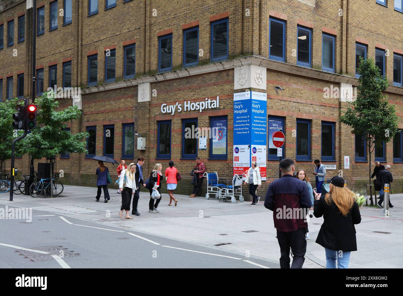 LONDON, UK - 8. JULI 2024: People Walk by Guy's Hospital in London, UK. Es ist ein Krankenhaus des NHS im Stadtteil Southwark. Stockfoto