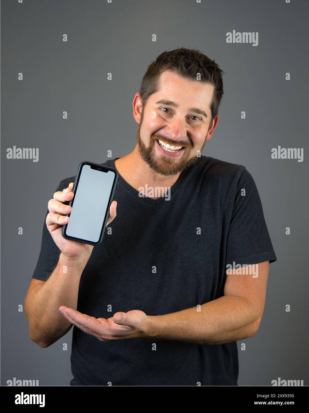 Selbstporträt-Mann, der Smartphone mit leerem Bildschirm für Textüberlagerung hält Stockfoto