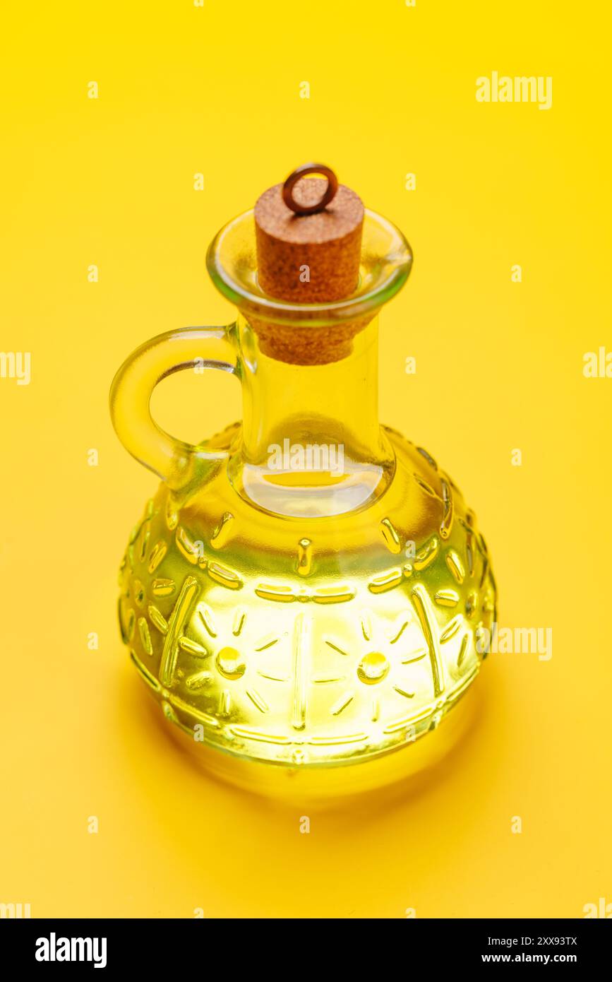 Eine elegante Flasche Olivenöl, perfekt für kulinarische Zwecke, hoch auf gelbem Hintergrund Stockfoto