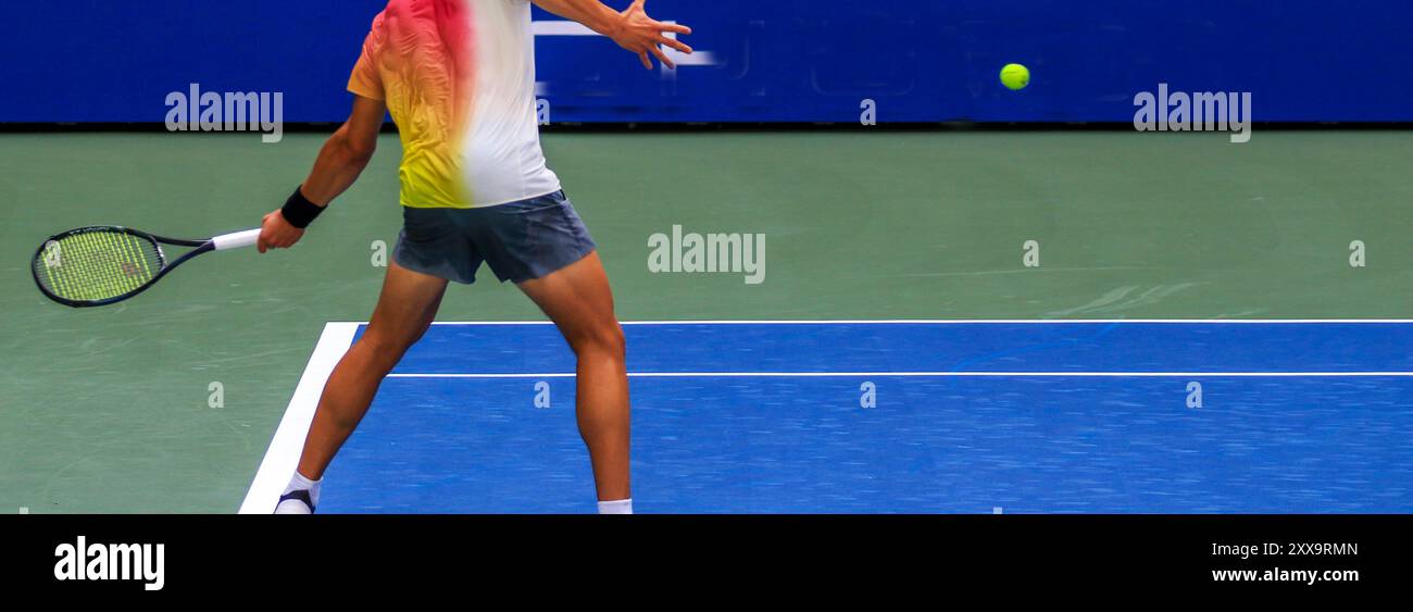 Seitenansicht eines Tennisspielers, der während eines Spiels seinen Schläger mit einer starken Vorderhand schwingen soll. Stockfoto