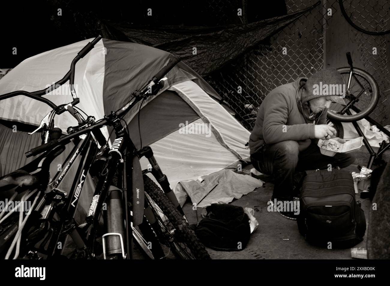 ARC-0010-BW...WASHINGTON - Obdachloser genießt ein warmes Abendessen von Angel Resource Connection auf seinem Campingplatz unter der Interstate 5 in Everett. Stockfoto