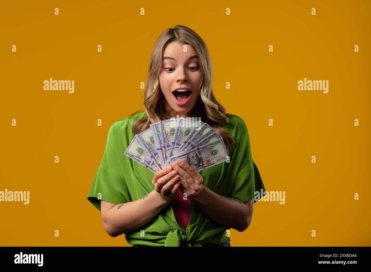 Reiche Frau mit Geld. Stilvolles Studentenmädchen auf Gelb, Dollar. Gehalt. Stipendium, Bezahlung. Hochwertige Fotos Stockfoto
