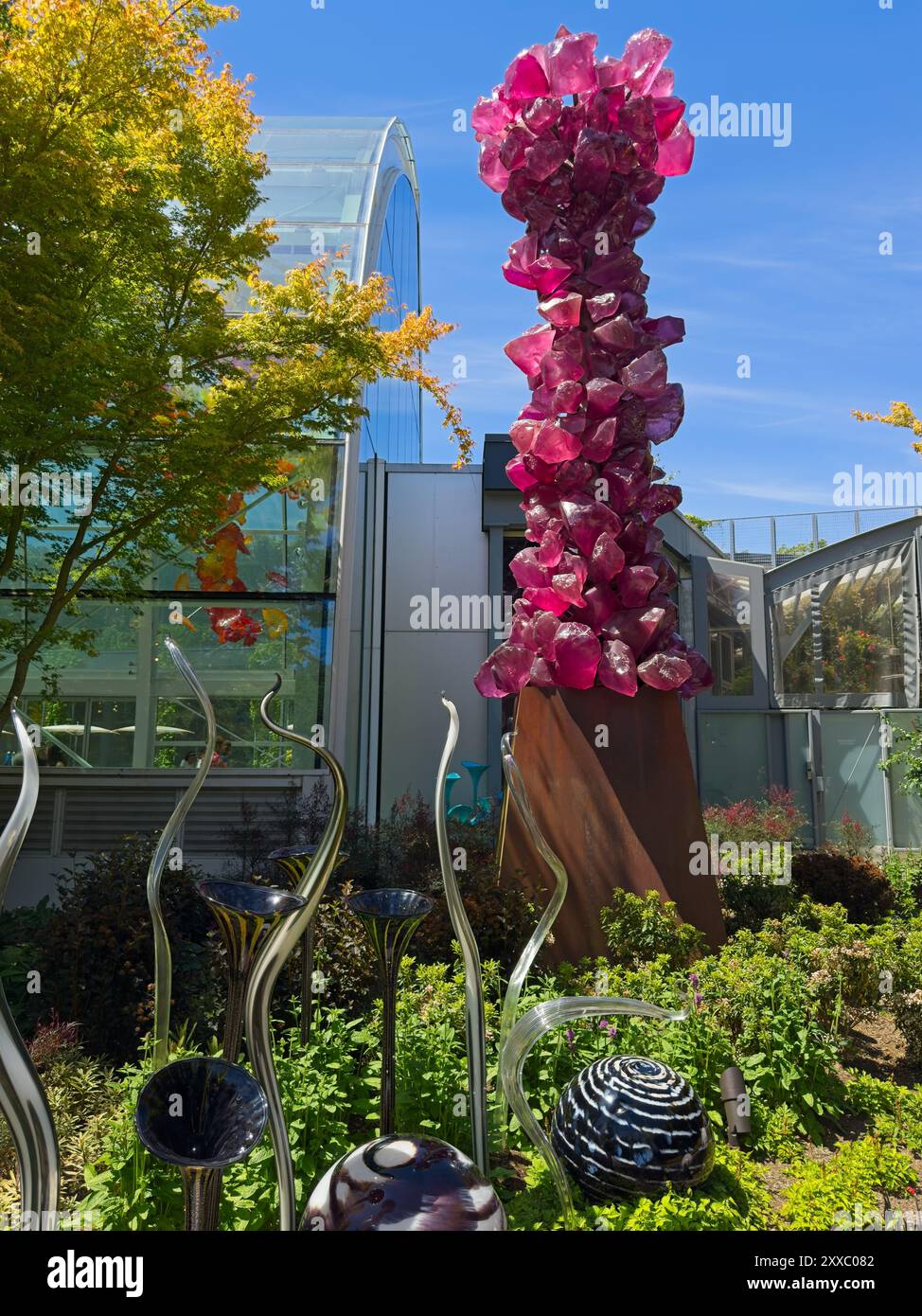 Seattle, WA - 21. Juni 2024: Eine Steinsäule aus mundgeblasenem Glas steht im Garten über Glaskugeln und wirbelt bei Chihuly Gardens and Glass in Stockfoto