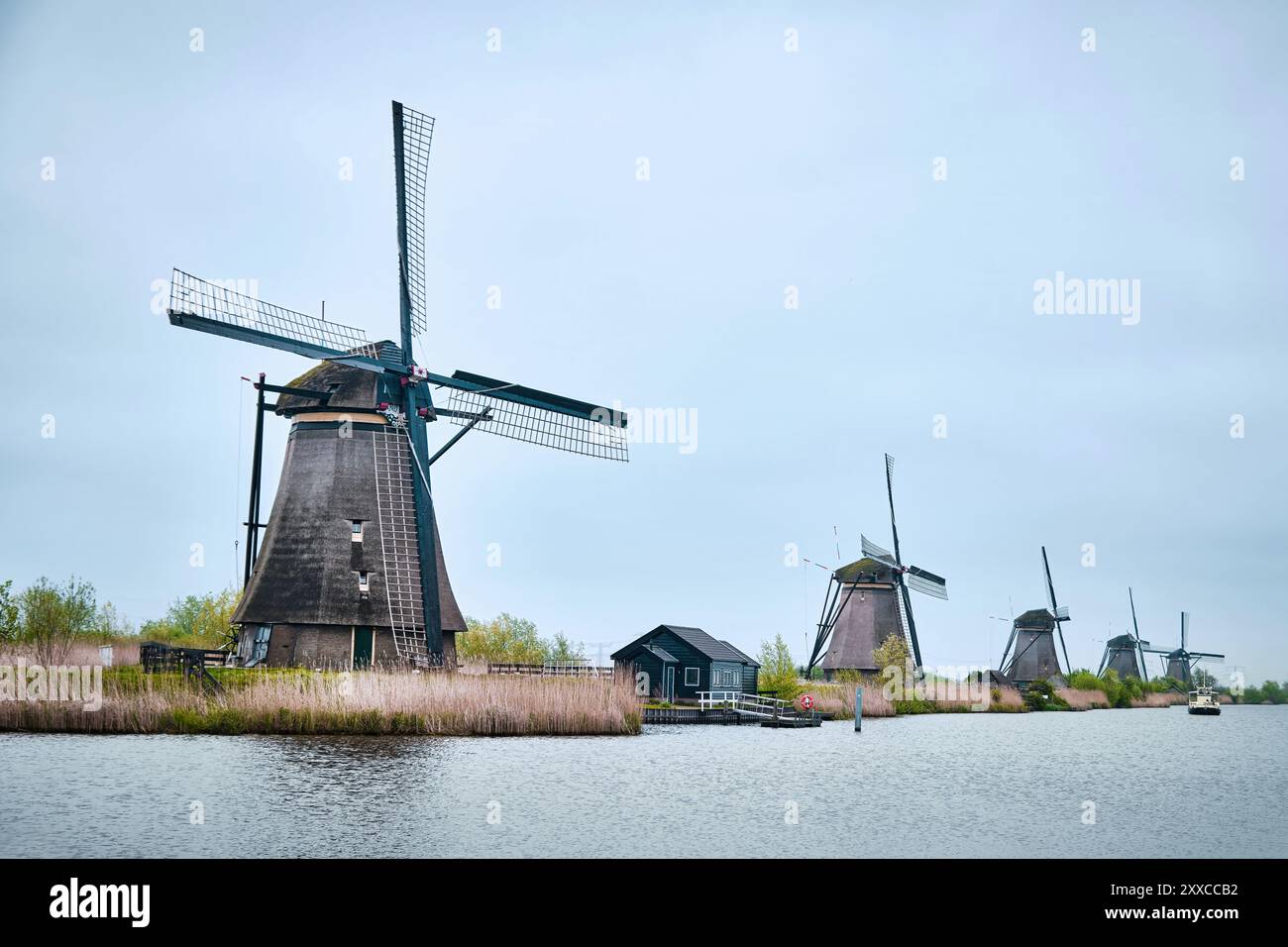 Kinderdijk, Rotterdam, Niederlande - 11. April 2024: Historische Windmühlen und ein Fluss, der in Kinderdijk vorbeifließt. 19 Windmühlen wurden um 1740 gebaut Stockfoto