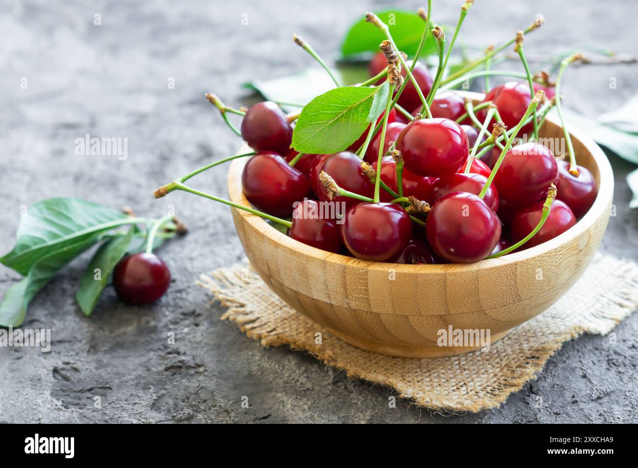 Frische reife Sauerkirschfrüchte in der Schüssel auf rustikalem Tisch, rote Sommerfrüchte Stockfoto