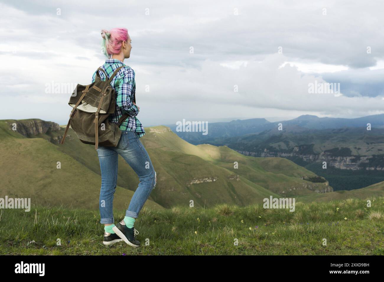 Studentenmädchen mit Rücken im Freien auf dem Land in Sommerferien lächelnd. Kaukasische Studentin auf einer Wanderung Stockfoto