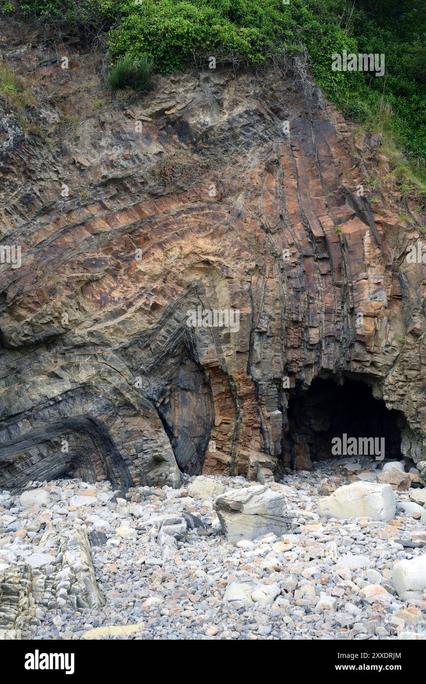 Falten von Bettenflugzeugen am Monkstone Point, Saundersfoot, Wales. Eine kleine (1,5 m hohe) Meereshöhle wurde durch Wellenbewegung am Fuß der Klippe gebildet. Stockfoto