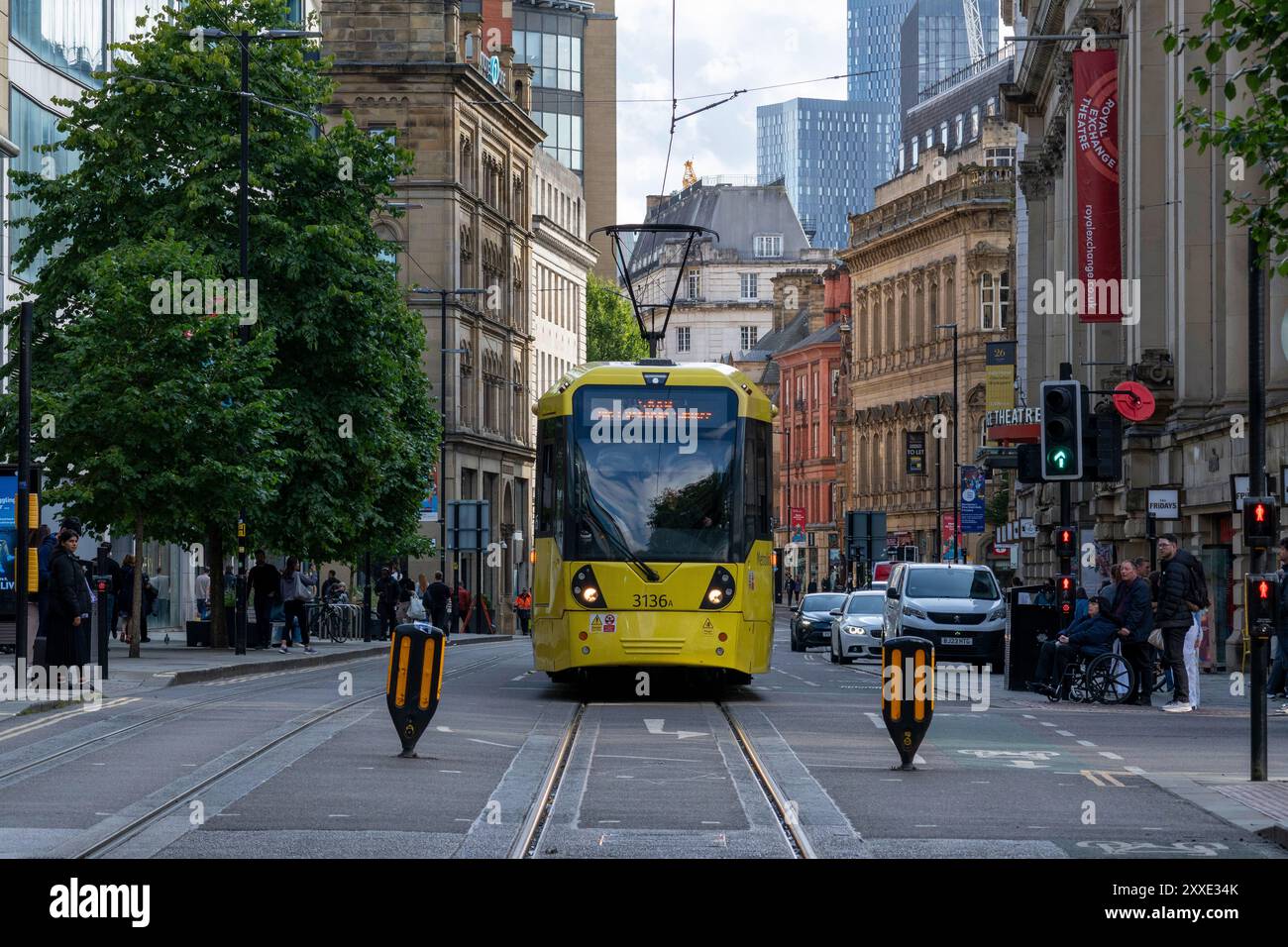 Eine geschäftige Cross Street in Manchester und gelbe Metro-Lin Tram vorbei Stockfoto