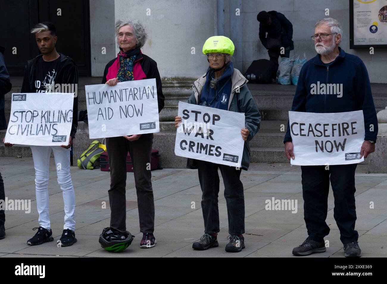 Eine Gruppe von Friedensaktivisten zeigt verschiedene Zeichen für Frieden und Krieg auf dem St. Peter's Square in Manchester, Großbritannien. Stockfoto