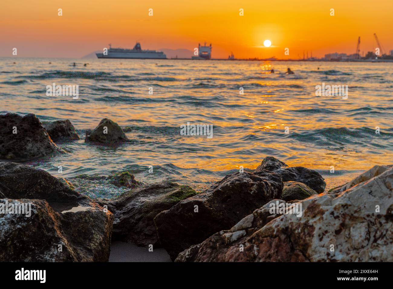 Sonnenuntergang am Strand in der Nähe der Stadt Vlorë in Albanien, die sich an der Bucht von Vlorë ausbreitet und von den Ausläufern der Ceraunischen Berge Ao umgeben ist Stockfoto