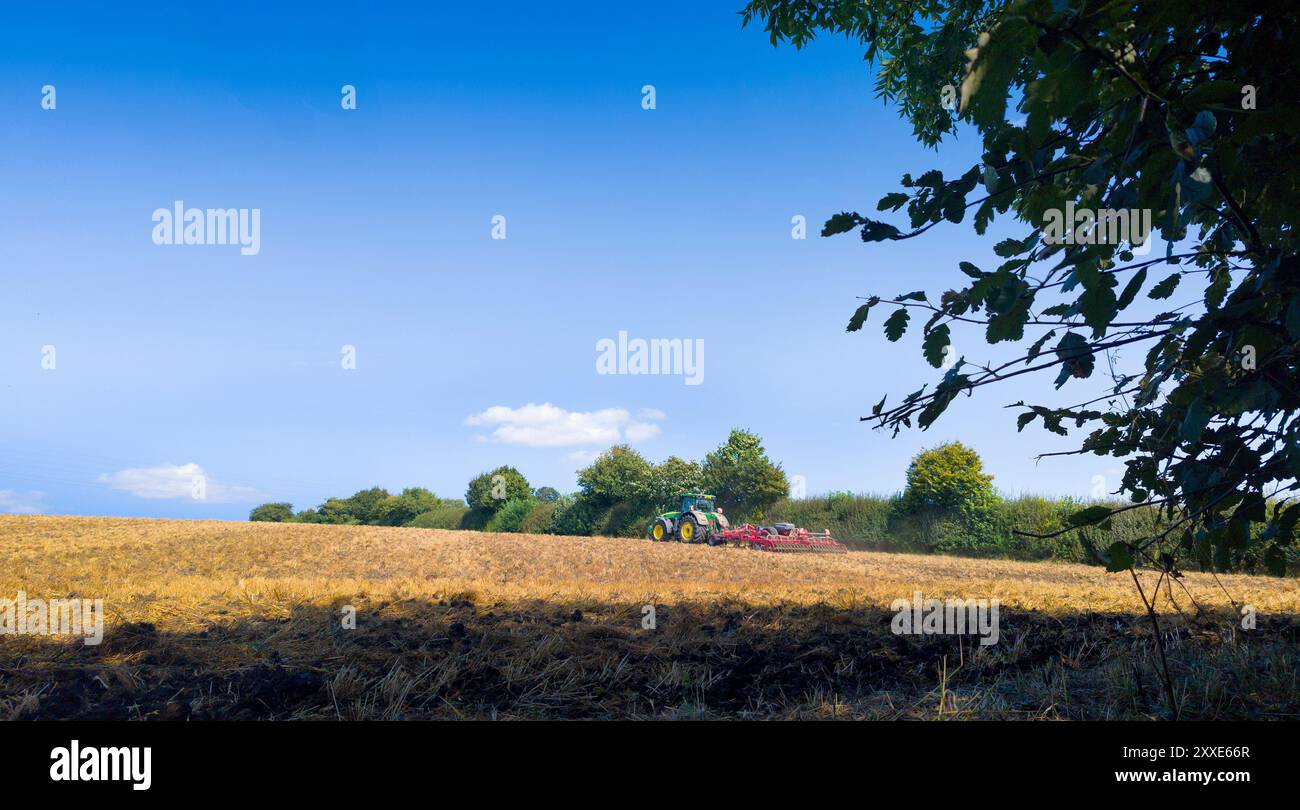 Ackerbaubetrieb, Traktor Vorbereitung des Landes nach der Ernte, August 2024, Großbritannien Stockfoto