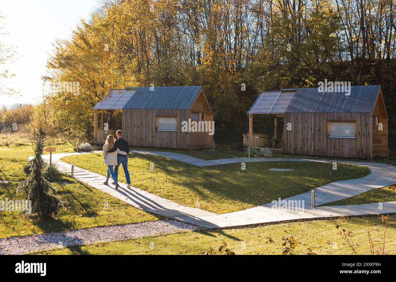 Umarmtes Paar genießt atemberaubende umliegende Landschaften des Glamping Resorts. Naturerlebnis und Entspannungskonzepte. Stockfoto