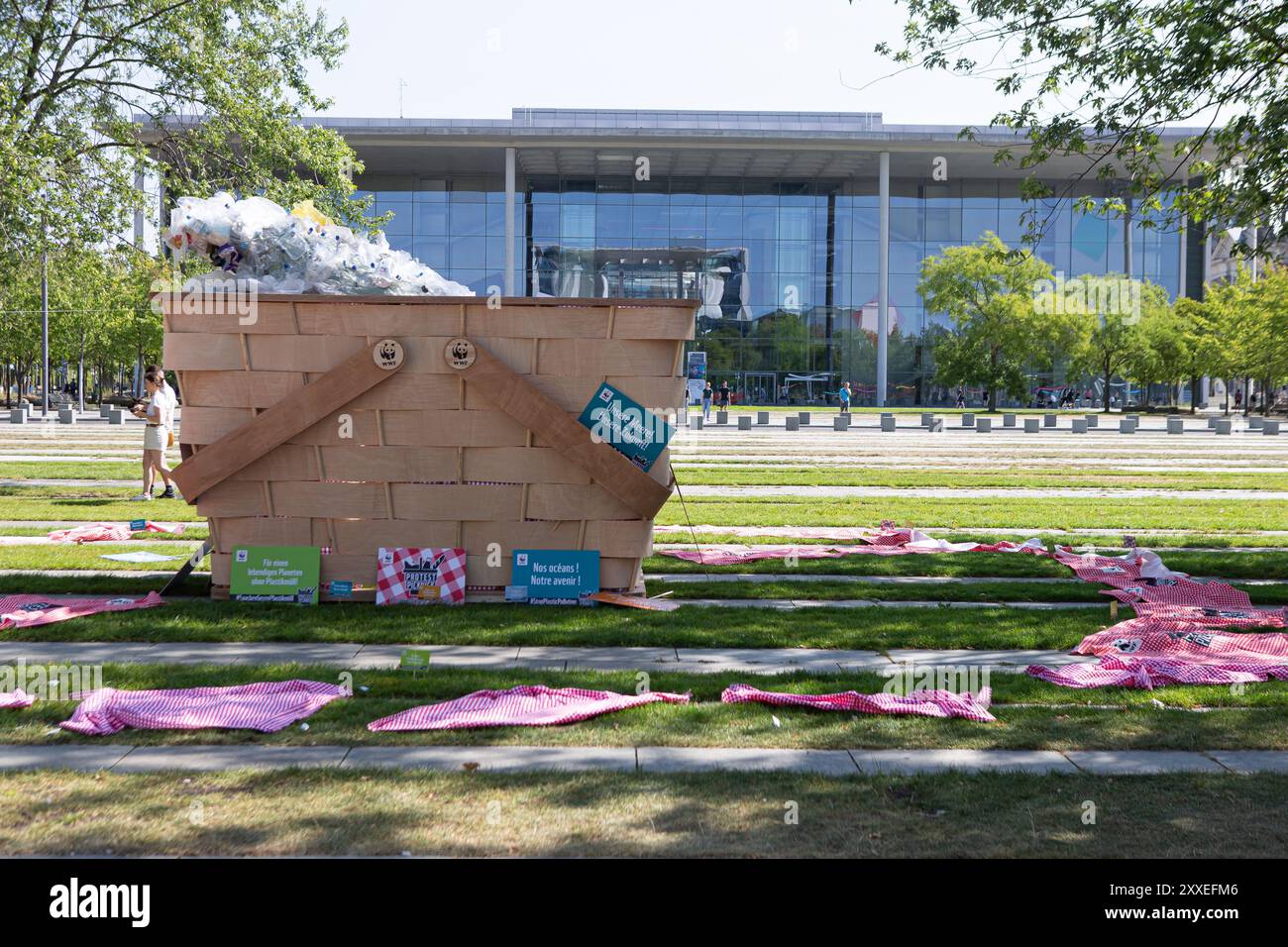 Berlin, Deutschland, 24. September 2024. Umweltaktivisten nehmen an einem bundesweiten Protestpicknick des WWF Deutschland gegen die Plastikkrise vor dem Bundeskanzleramt in Berlin teil. Die Demonstranten versammeln sich mit bunten Bannern und einem riesigen symbolischen Picknickkorb, der mit Plastikabfällen gefüllt ist, und fordern einen starken globalen vertrag der Vereinten Nationen, um die Plastikverschmutzung während der laufenden UN-Verhandlungen zu beenden. Felix Wolf/Alamy Live News Stockfoto