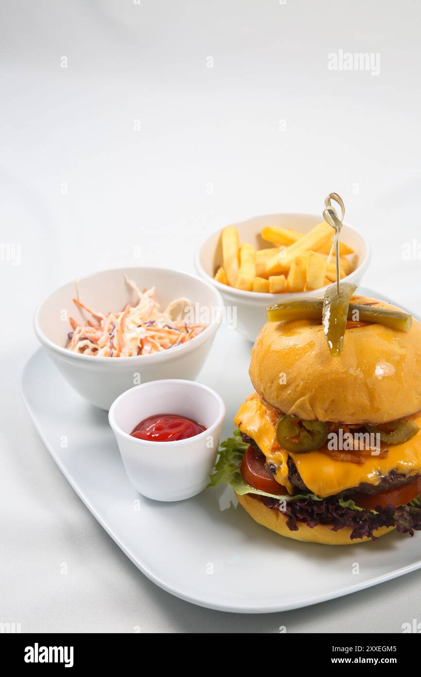 Eine vertikale Aufnahme eines Hamburger, Pommes frites mit Sauce auf weißem Hintergrund Stockfoto