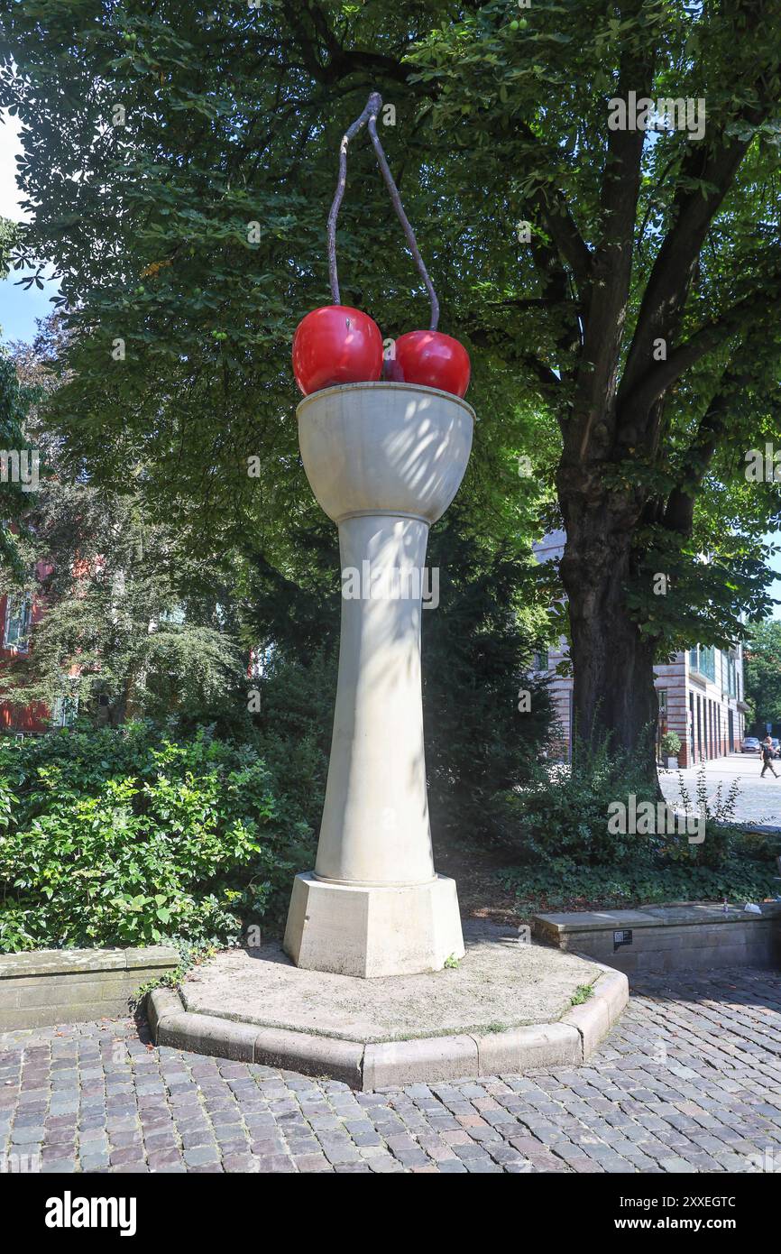 Kunst im öffentlichen Raum. Öffentliche Sammlung der Skulptur Projekte. Thomas Schütte. Kirschensäule. Skulptur aus Sandstein und lackiertem Aluminium. Standort: Harsewinkelplatz, permanente Aufstellung. Münster, Nordrhein-Westfalen, DEU, Deutschland, 11.08.2024 *** öffentliche Kunst öffentliche Sammlung Skulpturenprojekte Thomas Schütte Kirschsäule Skulptur aus Sandstein und lackiertem Aluminium Standort Harsewinkelplatz, Dauerinstallation Münster, Nordrhein-Westfalen, DEU, Deutschland, 11 08 2024 Stockfoto