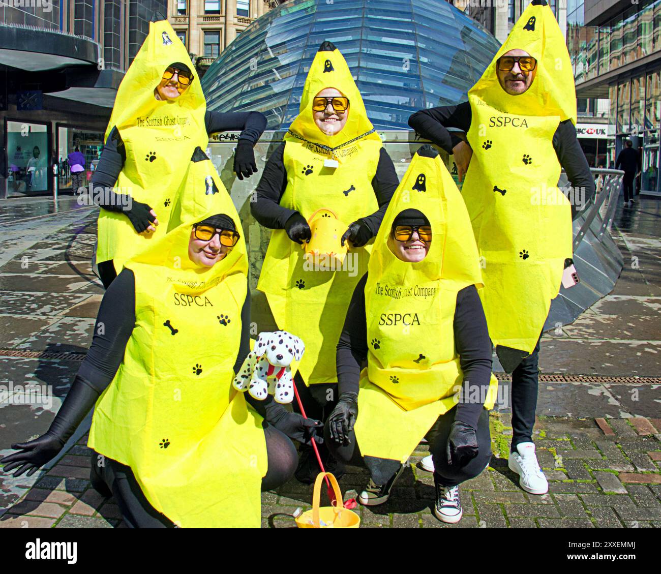 Glasgow, Schottland, Großbritannien. August 2024. UK Wetter: Glasgow paranormale Ermittler The Scottish Ghost Company, die sich einige der gruseligsten Orte im ganzen Land ansehen, gaben Geister auf und machten einen Bananenspaziergang durch das Stadtzentrum, um für Sspca-Wohltätigkeitsorganisationen zu sammeln. Nass im Stadtzentrum nach dem Sturm sah Einheimische und Touristen erleichtert. Credit Gerard Ferry/Alamy Live News Stockfoto