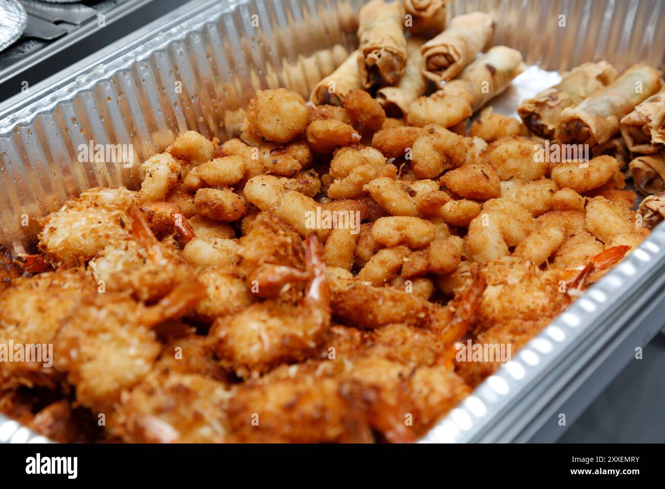 Blick auf ein Catering-Tablett mit frittierten Meeresfrüchtevorspeisen und Eierrollen. Stockfoto