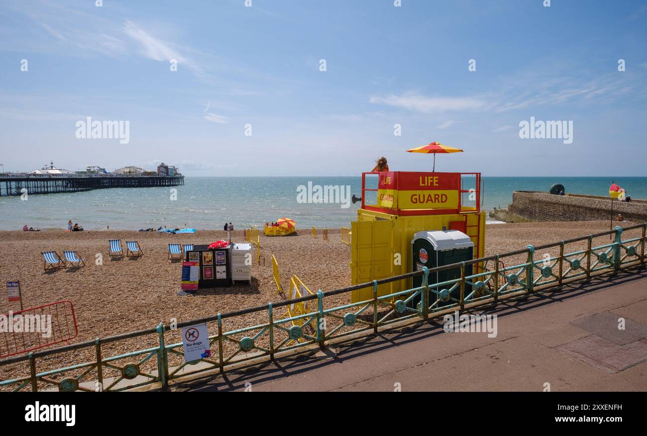 Ein Blick auf die Landschaft von Brighton Beach mit Life Guard Tower und Pier an einem sonnigen Tag. Stockfoto