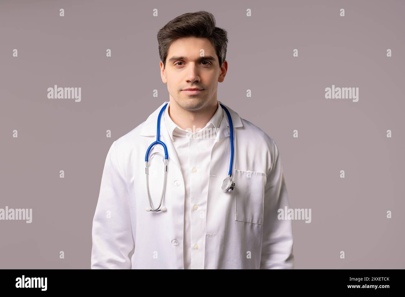 Porträt eines freundlichen gutaussehenden 30er Jahre alten Arztmannes in weißer medizinischer Fellform im Atelier. Krankenhausberufe, Pharmazie, Gesundheitswesen s Stockfoto