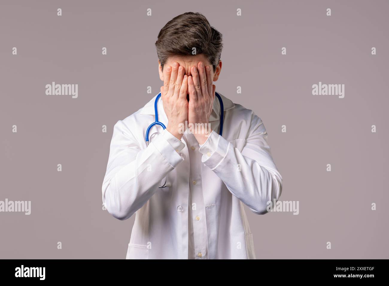 Enttäuschter Arztmann in weißer medizinischer Fellform mit Facepalm. Bedauern, Misserfolg, Unzufriedenheit, Zeitverschwendung, Probleme in der Klinik, weiß Stockfoto