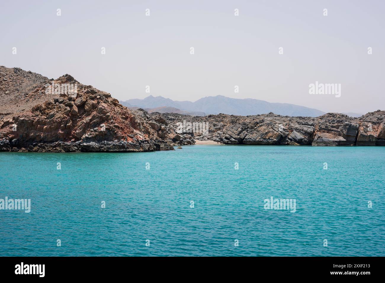 Felsige Klippen und kleiner Strand in einer fjordartigen Umgebung der Halbinsel Musandam, Sultanat Oman Stockfoto