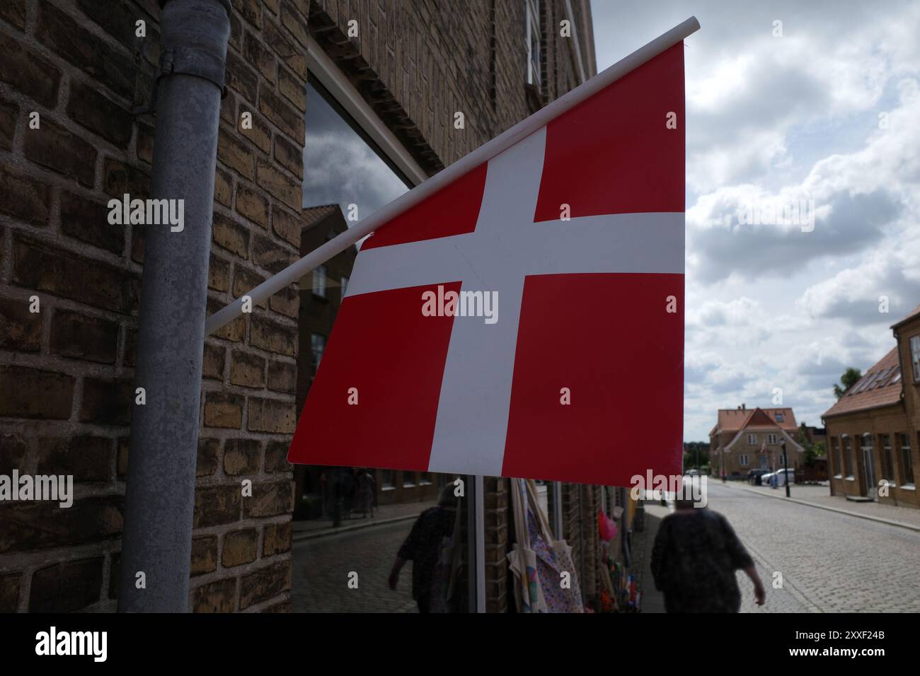 Eine kleine dänische Flagge hängt an der Fassade eines Ladens Stockfoto