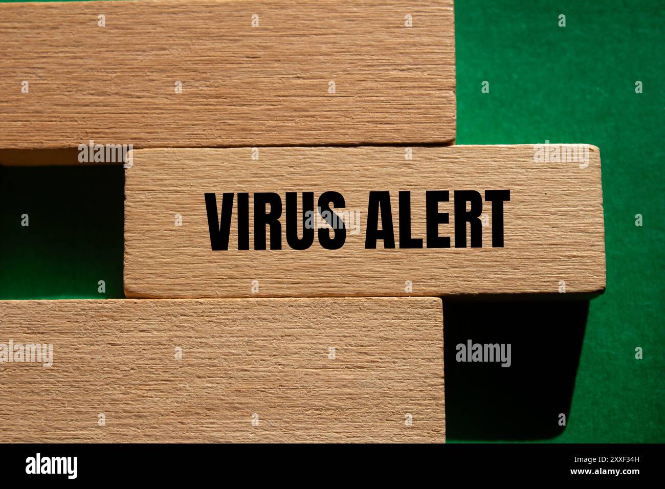 Viruswarnmeldung auf Holzblock mit grünem Hintergrund geschrieben. Konzeptionelles Virus-Warnsymbol. Kopierbereich. Stockfoto