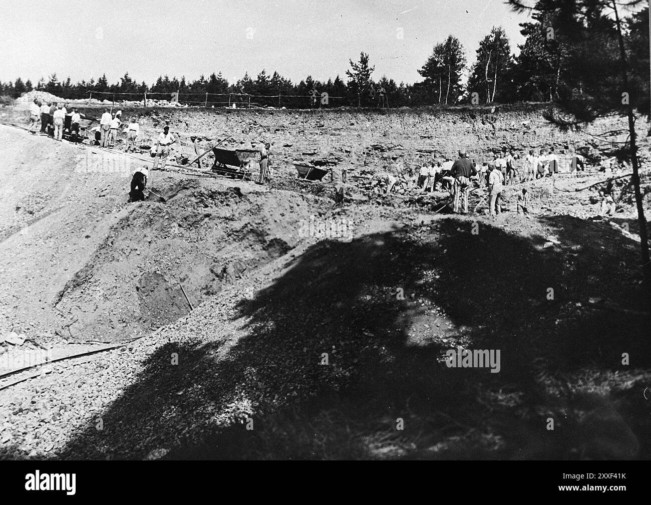 Zwangsarbeitsgefangene aus dem KZ Buchenwald wachen in einem Steinbruch auf. Buchenwald und seine 139 Unterlager waren Zwangsarbeitslager, keine Todeslager und es gab dort keine Gaskammern. Allerdings führten schlechte Bedingungen, Missbrauch und Hinrichtungen dort zu 56500 Toten. Am 11. April 1945 wurde sie von der US-Armee befreit. Das Foto stammt vom 27. September 197, also sind diese Männer Deutsche. Vor dem Krieg wurde das Lagersystem benutzt, um politische Gefangene, Andersdenkende, Homosexuelle und alle anderen zu unterbringen, die nicht dem Nazi-ideal entsprachen. Stockfoto