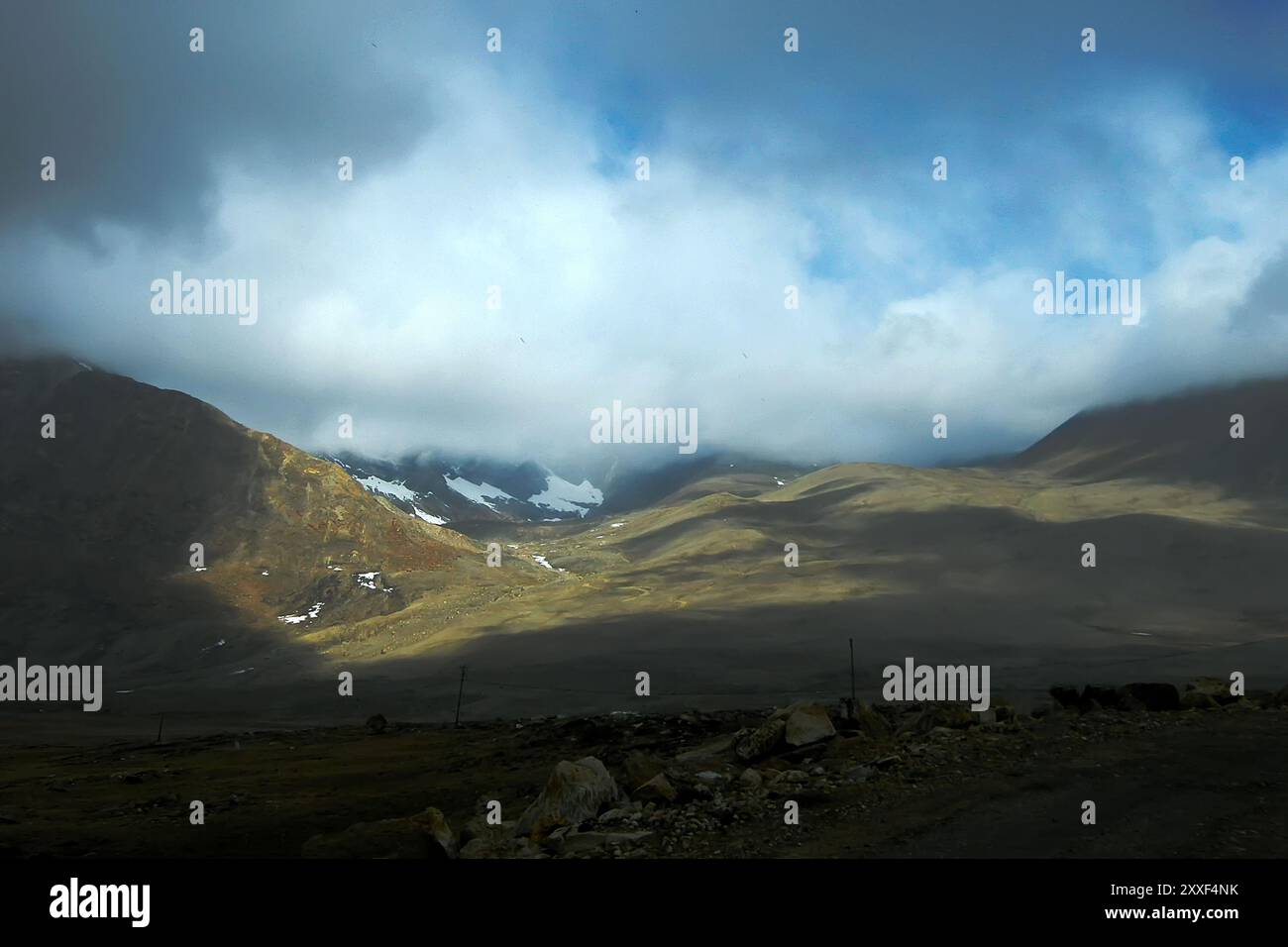 Spiel von Licht und Schatten auf den Bergen des Himalaya neben der Straße zum Gurudongmar Lake, Sikkim, Indien. Von Buddhisten, Sikhs und Hindus als heilig angesehen. Stockfoto