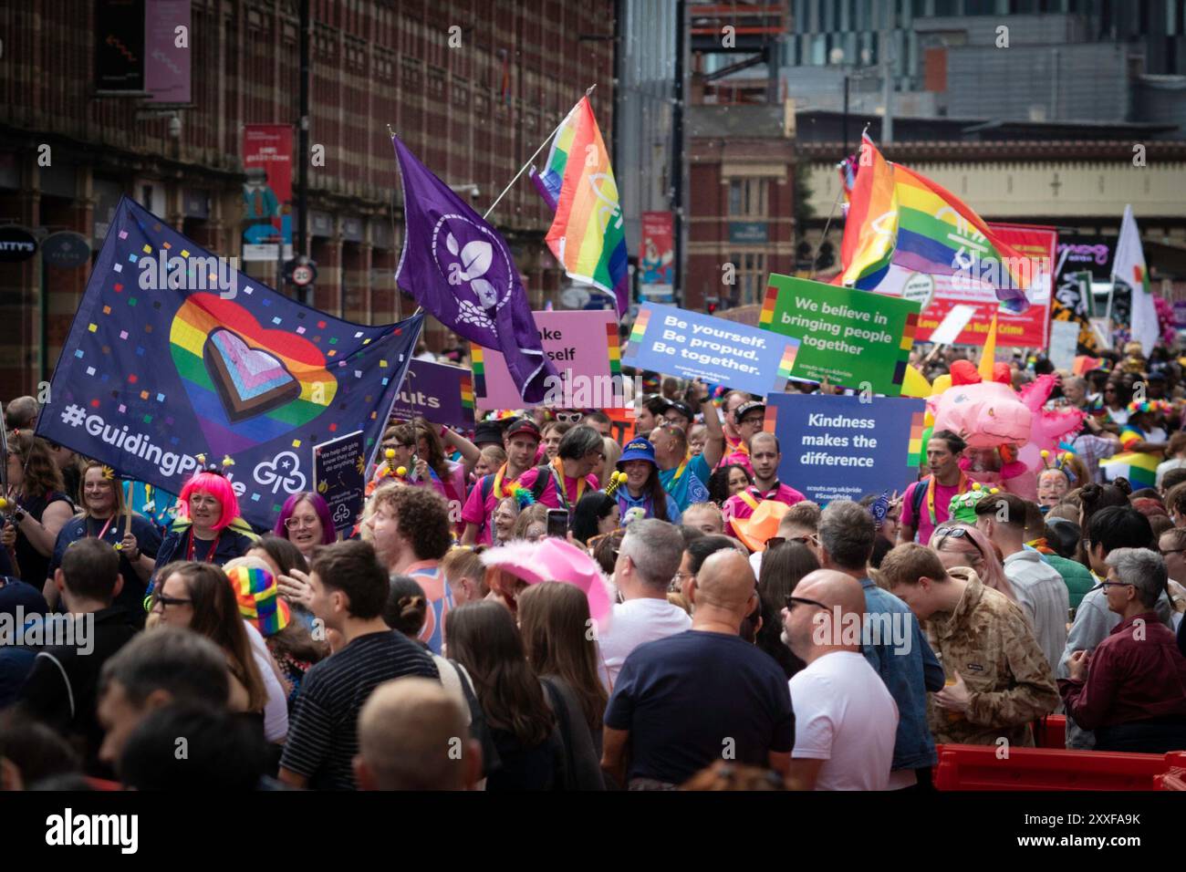 Manchester, Großbritannien. August 2024. Die LGBTQ-Community kommt während der Pride Parade mit Bannern und Flaggen zusammen. Die dreitägige Veranstaltung bietet Live-Musik und Partys in der ganzen Stadt, wobei die Hauptparade am Samstag stattfindet. Andy Barton/Alamy Live News Stockfoto