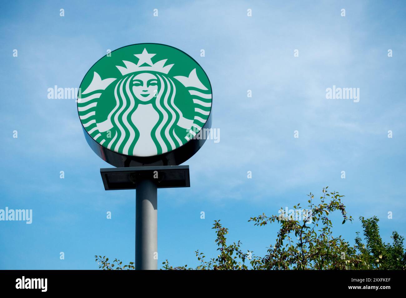 Unterschreibe das Starbucks Logo gegen den blauen Himmel Stockfoto