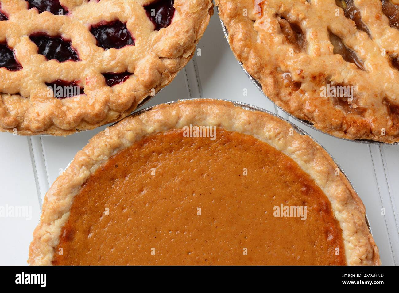 Nahaufnahme von drei verschiedenen frisch gebackenen Urlaubsplätzchen. Kürbis, Apfel und ein Beerenkuchen werden angezeigt. Stockfoto