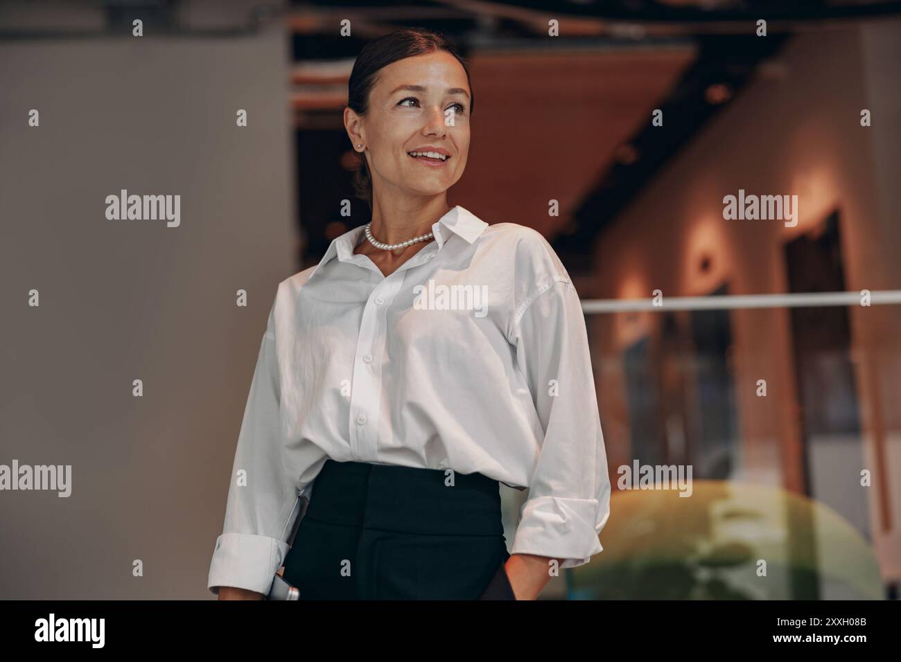 Selbstbewusste professionelle Frau in einer modernen und dynamischen Arbeitsumgebung Stockfoto