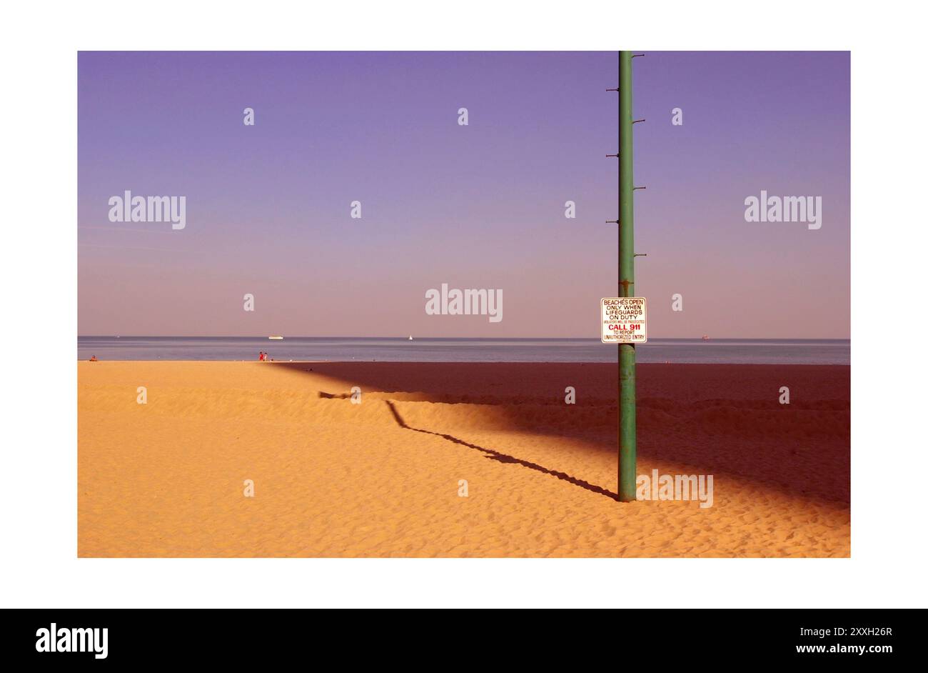 Ein Schild auf einem Lampenträger am Oak Street Beach in Downtown Chicago, mit Sand und Lake Michigan im Hintergrund Stockfoto