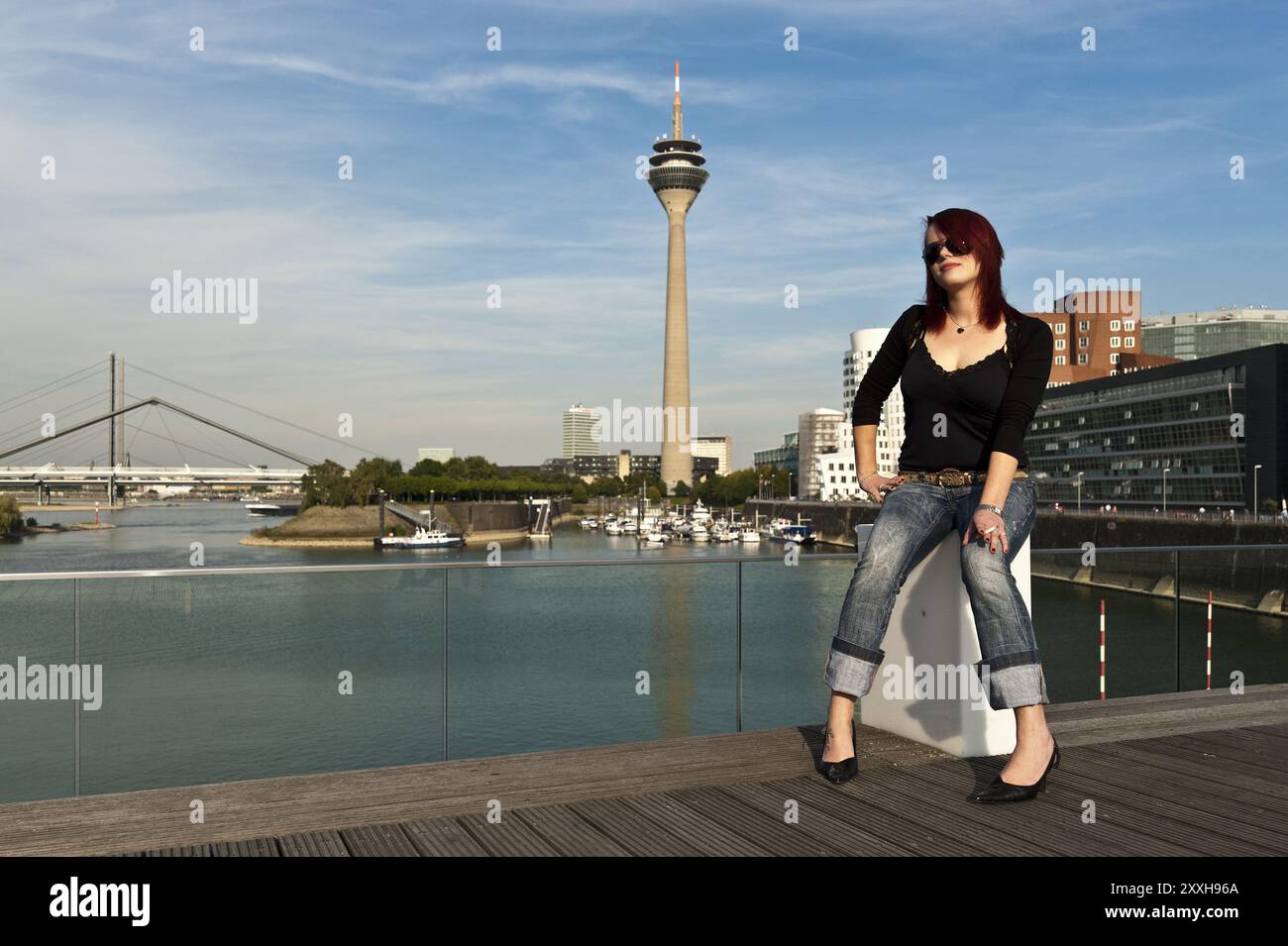 Junge Frau mit einer Zigarette im Düsseldorfer Medienhafen Stockfoto