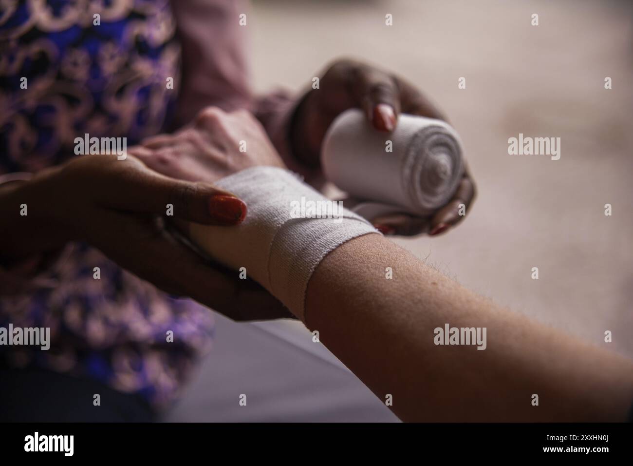 Hände beim Anlegen eines Verbands Stockfoto