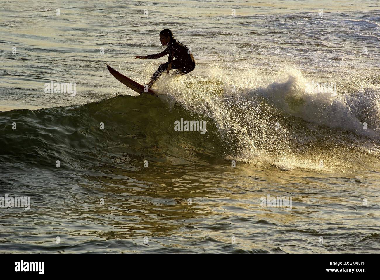 Junge Surfen kleine Welle am Arpoador Beach in Ipanema während des Sonnenuntergangs Stockfoto