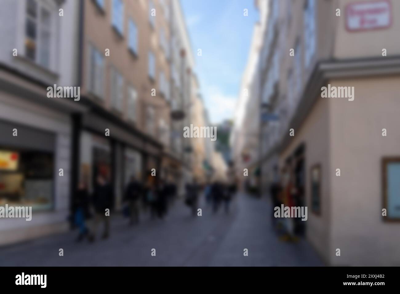 Ein verschwommenes Bild einer Gasse in Salzburg, Österreich. Der Hintergrund ist unscharf, wodurch ein Bokeh-Effekt entsteht. Stockfoto