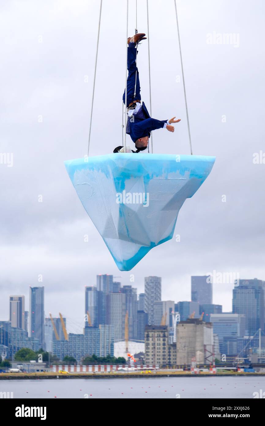 London, UK, 24. August 2024. Bei der europäischen Premiere von 'TAW' beim Greenwich+Docklands International Festival (GDIF) waren drei Luftkünstler auf einem schmelzenden 2,5-Tonnen-Eisblock, der über der Gallions Point Marina über acht Stunden schwang. Die am 25. August erneut wiederholte Performance, die von der University of East London in Newham aus zu sehen ist, wurde von der australischen Theaterkompanie Legs on the Wall nach den Buschbränden von 2019/20 geschaffen und fordert die Menschheit auf, die Klimakrise zu bewältigen. Quelle: Eleventh Photography/Alamy Live News Stockfoto