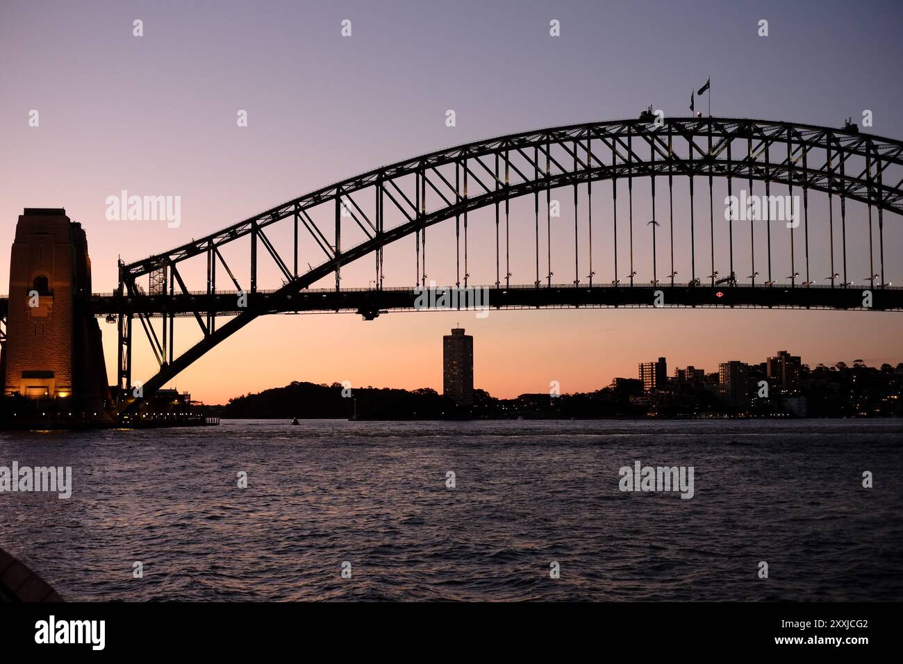 Sydney, Australien, das Art déco-Design Sydney Harbour Bridge, Dawes Point in Silhouette bei Sonnenuntergang mit Sonnenuntergang hinter dem südlichen Pylon, Stockfoto