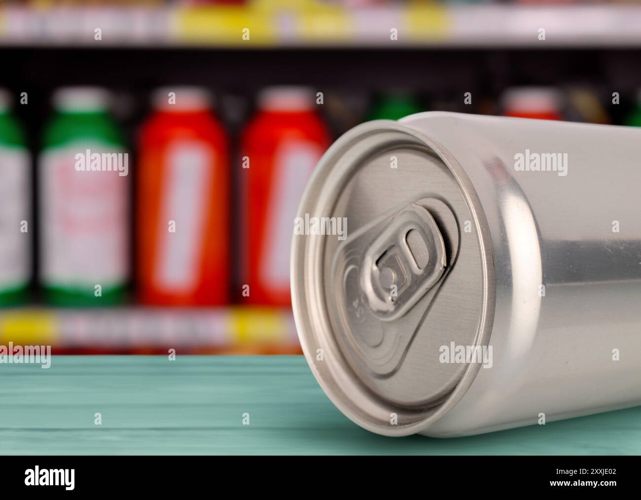 Eine Metalldose mit einem Getränk auf dem Tisch vor dem Hintergrund von Regalen mit Getränken, Makro. Stockfoto