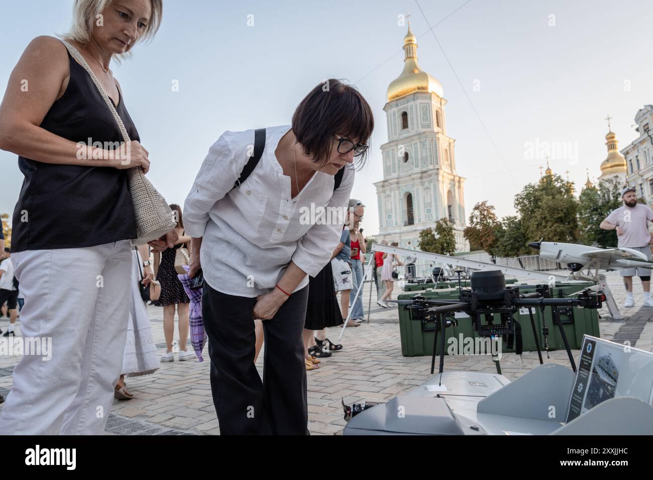 Kiew, Ukraine. August 2024. Eine Frau, die auf ein unbemanntes Luftfahrzeug blickt, das möglicherweise an vorderster Front eingesetzt wird. Das ukrainische Innenministerium stellt unbemannte Waffen und Robotik vor, einschließlich Aufklärungs-UAVs, Unterwasserdrohnen, Fahrzeuge und Ausrüstung, die künftig an vorderster Front eingesetzt werden, und andere Aspekte. Kiew hielt am Unabhängigkeitstag eine Militärparade ab, hat sie aber seit Kriegsbeginn 2022 ausgesetzt. Quelle: SOPA Images Limited/Alamy Live News Stockfoto