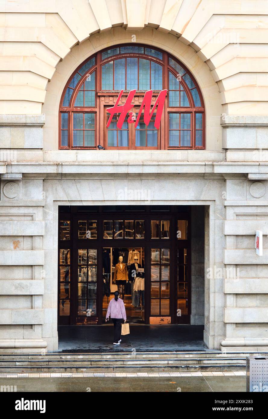 Weibliche Käuferin geht in das H&M Mode- und Bekleidungsgeschäft im historischen ehemaligen General Post Office Building in Perth, Western Australia. Stockfoto