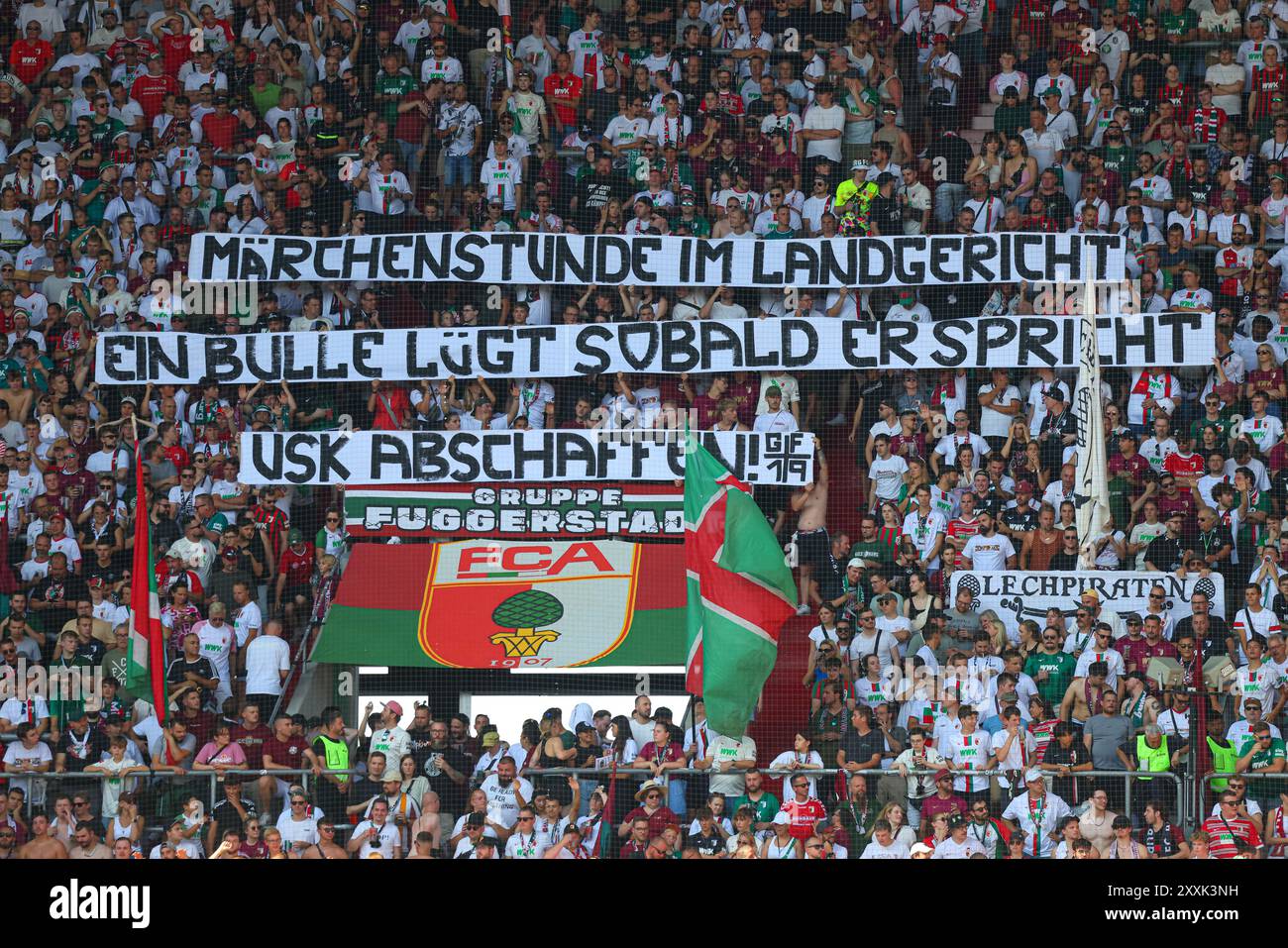 Fanblock Augsburg, „Märchenstunde im Landgericht“, Spruchband wegen dem aktuellen Polizisten-Prozeß, Schuß aus der Dienstpistole eines Polizisten vor der WWK-Arena vor etwa einem Jahr; FC Augsburg vs. Werder Bremen, 1. SPIELTAG; DFL-VORSCHRIFTEN VERBIETEN DIE VERWENDUNG VON FOTOS ALS BILDSEQUENZEN UND/ODER QUASI-VIDEO. Stockfoto