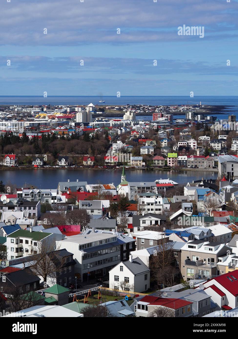 Eine malerische Aussicht auf farbenfrohe Häuser und einen Wasserkörper in einer urbanen Umgebung mit klarem blauen Himmel, die die harmonische Mischung aus Architektur und zeigt Stockfoto