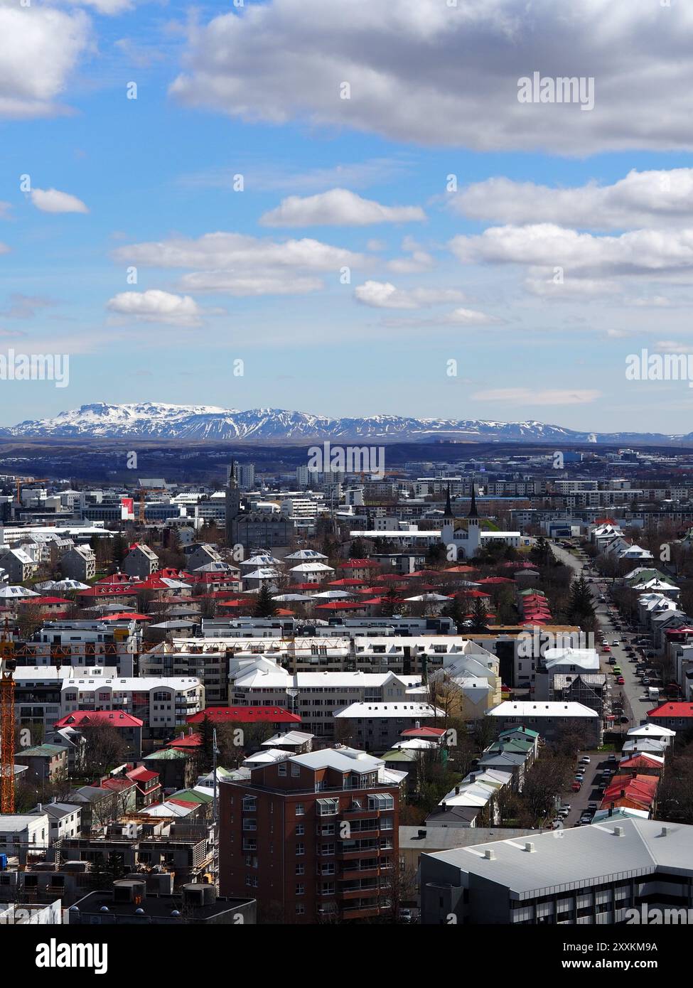 Ein weicher Blick auf eine Stadtlandschaft mit einer Mischung aus roten und modernen Gebäuden, mit schneebedeckten Bergen im Hintergrund unter einem Teil Stockfoto