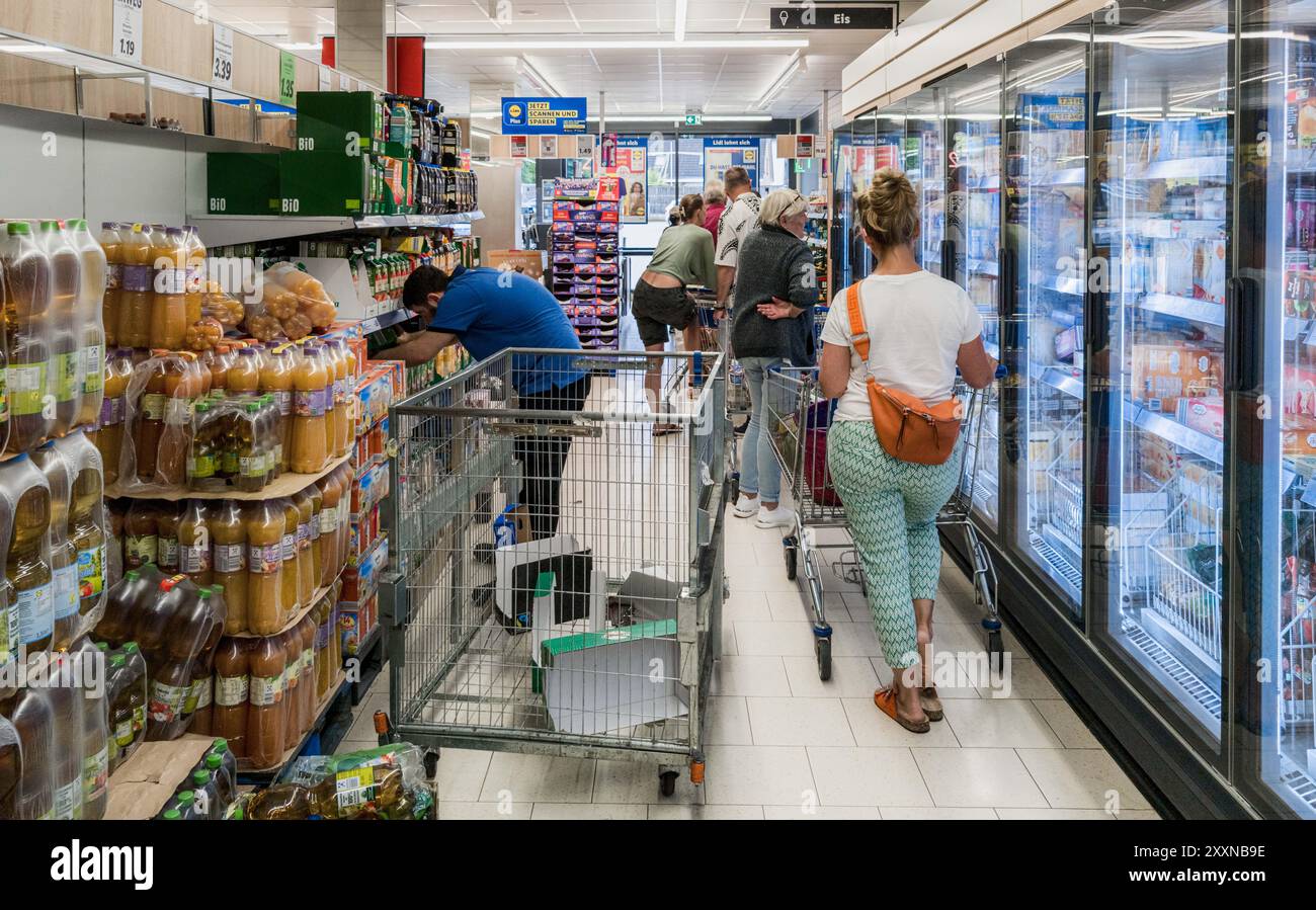 Hamburg, Deutschland. August 2024. Kunden stehen an der Kasse in einem LIDL-Supermarkt. Quelle: Markus Scholz/dpa/Alamy Live News Stockfoto