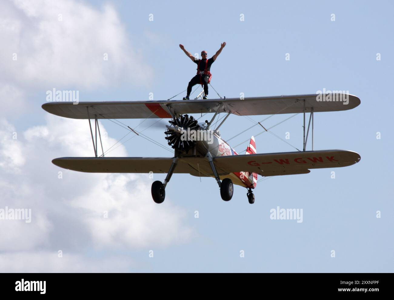 Ein Wing Walker macht eine Fahrt mit einem Boeing A-75L300 Stearman der Wing Walk Company im Headcorn Aeodrome in Kent Stockfoto