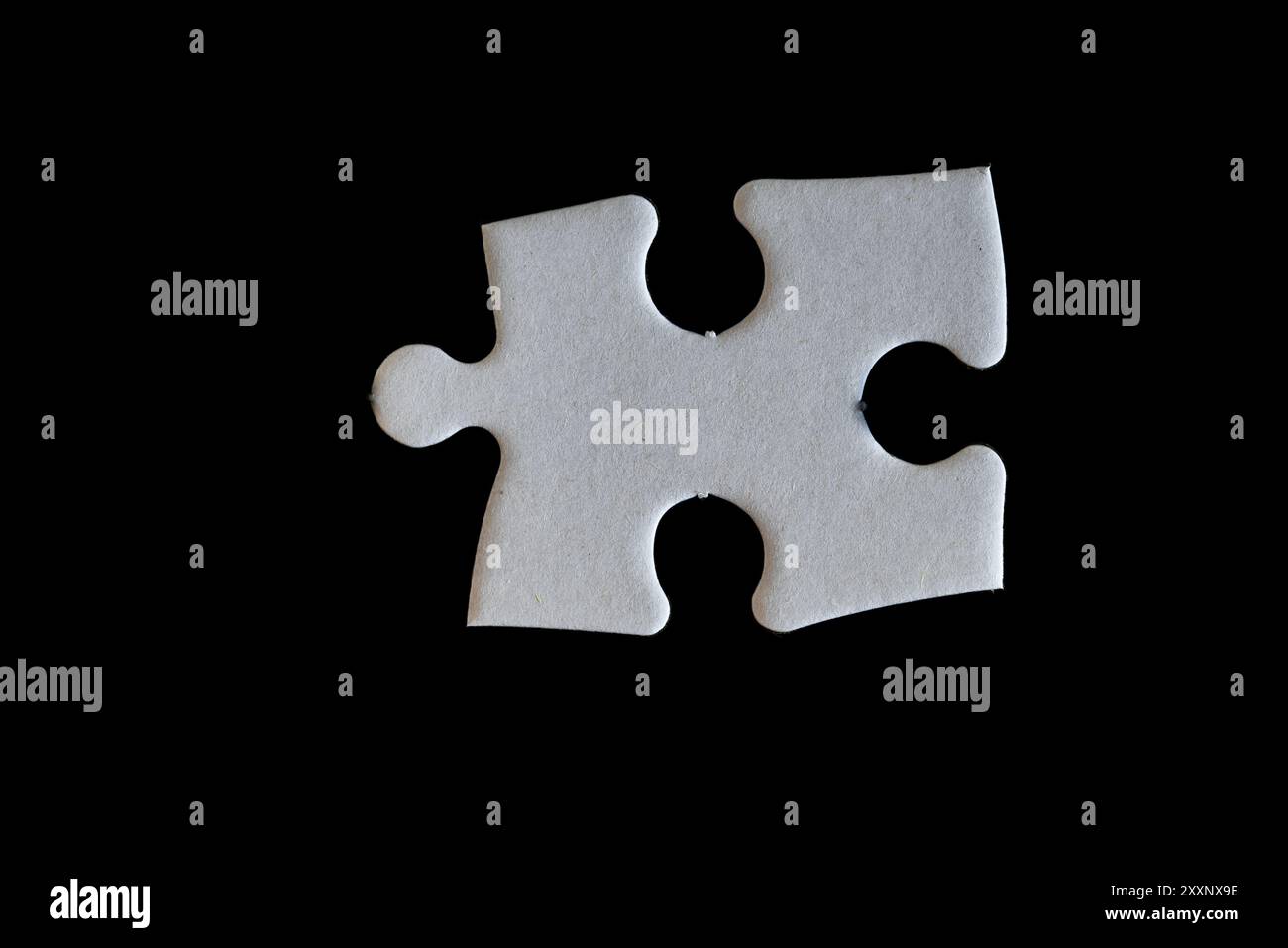 Ein einzelnes Puzzlestück auf schwarzem Hintergrund Stockfoto